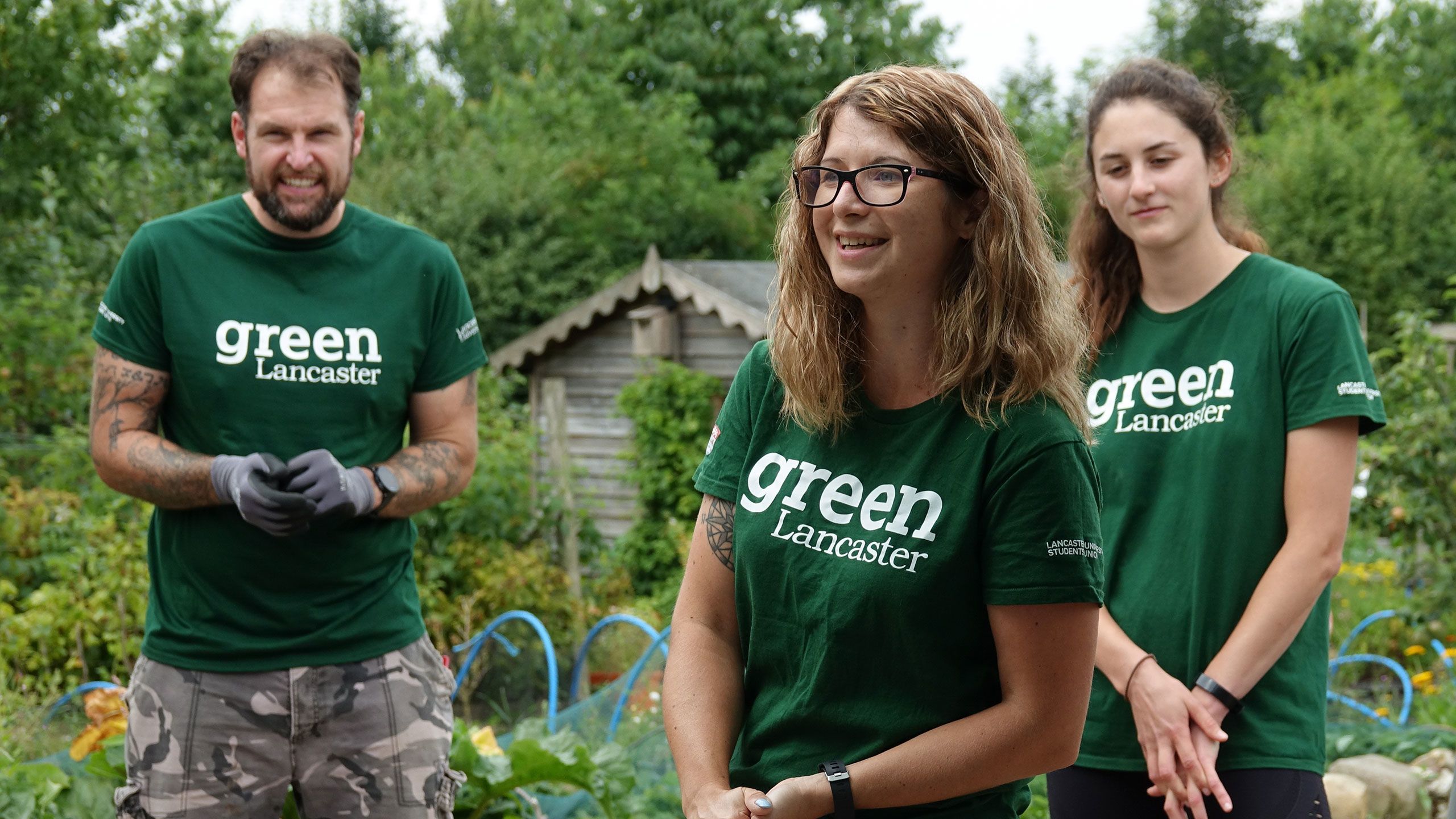 Students working outdoors wearing Green Lancaster t-shirts